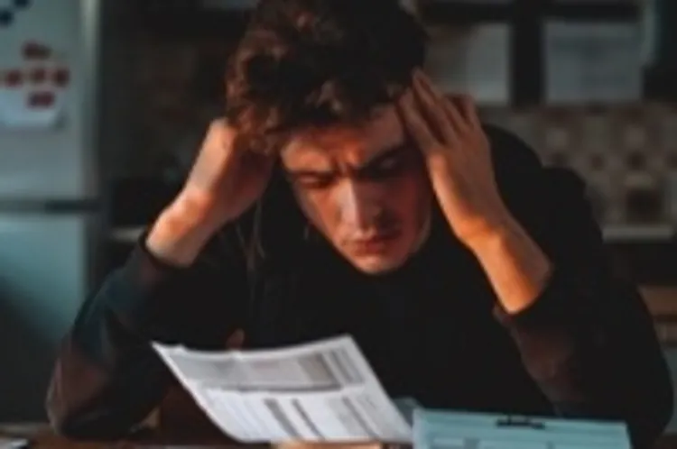 a frustrated-looking guy looking at forms