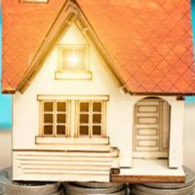 model house atop stacks of coins