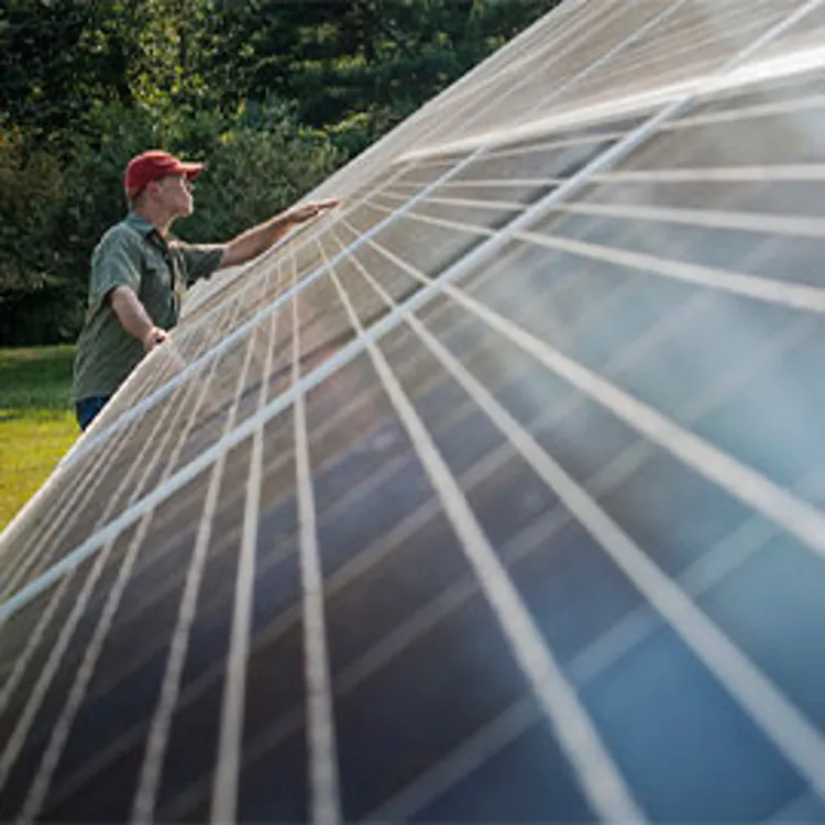 man inspecting angle of solar panel