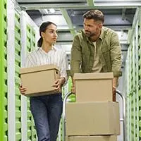 couple moving boxes into storage unit