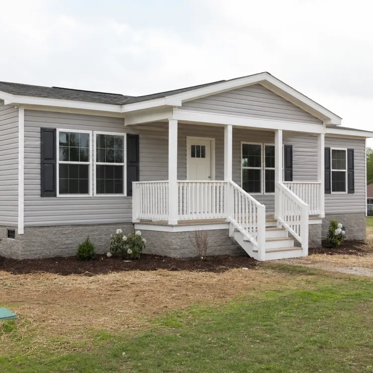 Gray manufactured home with white porch and black shutters on a grassy lot