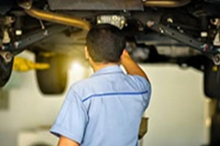 technician inspecting car unit lifted overhead