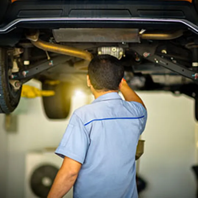 technician inspecting car unit lifted overhead