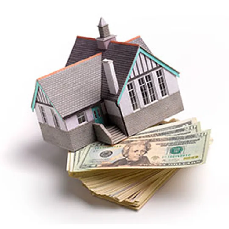miniature model house on top of dollar bills