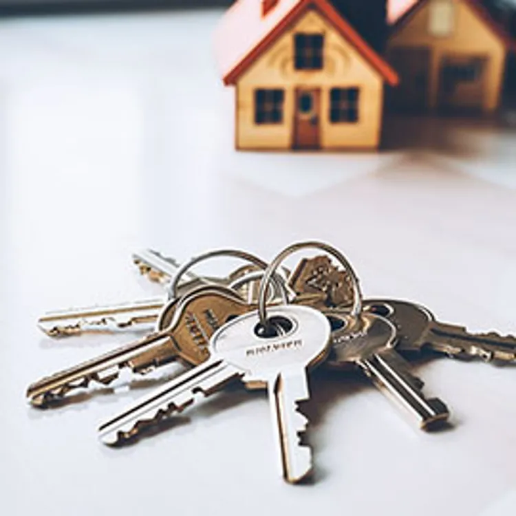 house keys in front of miniature model house