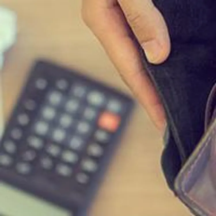 person looking at empty wallet