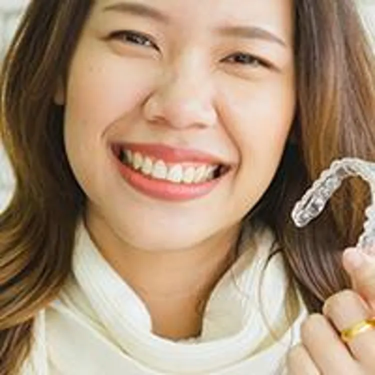 woman holding clear aligner