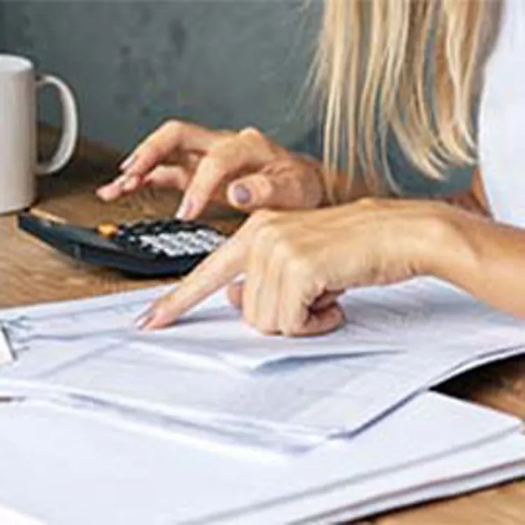 woman pointing at paper typing on calculator