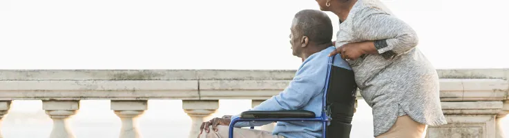 woman pushing husband in wheelchair