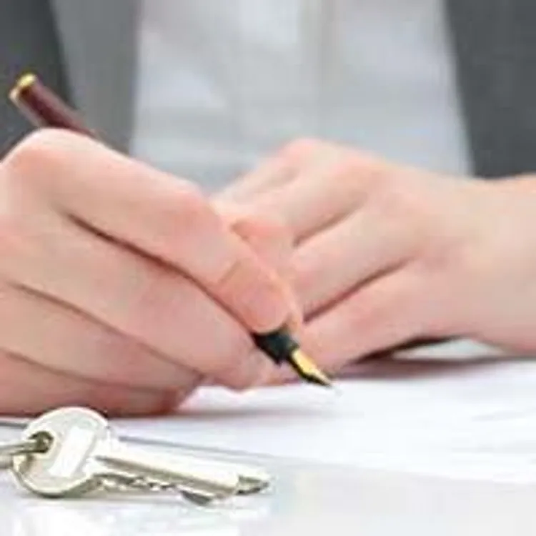 woman signing contact behind model home