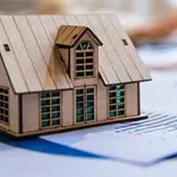 wooden model home on paperwork