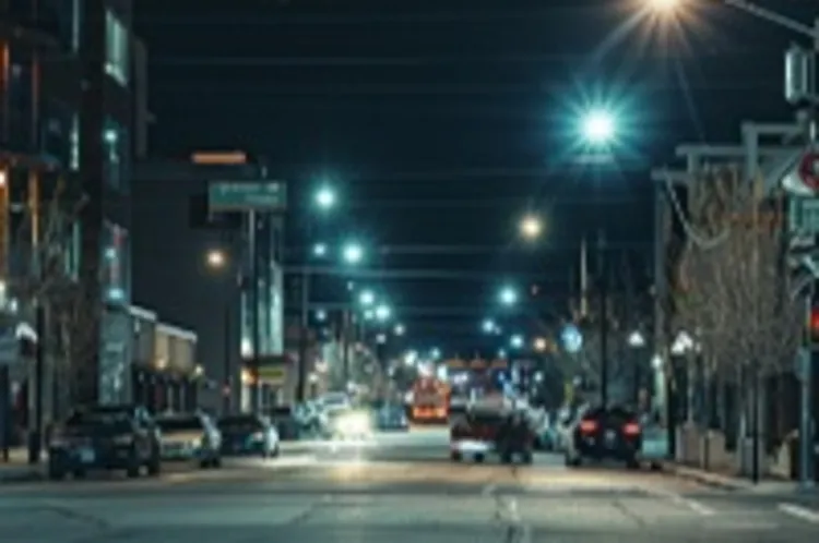 a downtown street at night with a few parked cars