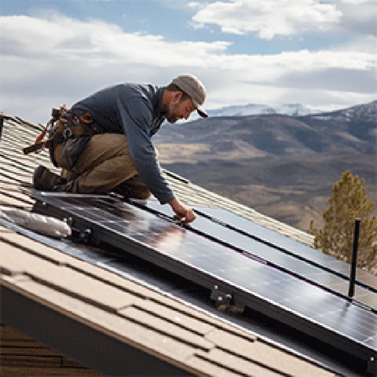 man installing solar panel on slanted roof
